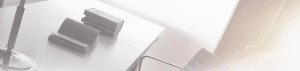angled image of desk with books stacked, one open and lamp fundraising studies